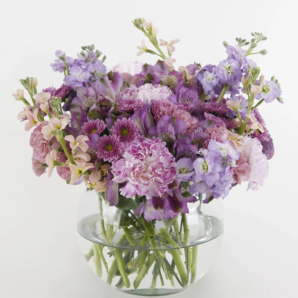 Delightful Discoveries Bouquet Fuller- lavender stock flowers, cream stock flowers, pink novelty carnations, purple alstroemeria flowers, purple button mums 