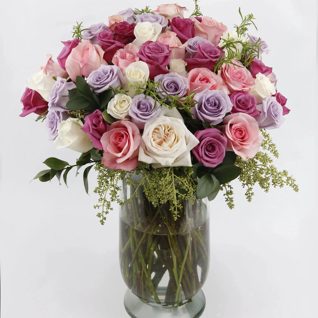 In Bloom Divine - purple roses , pink roses , cream roses , off-white roses , vase arrangement