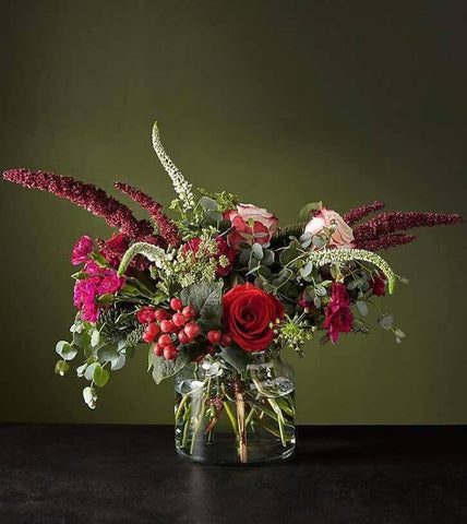 Reverie Bouquet™ by Toronto Flower Co. is an elegant holiday arrangement with a color palette of red, cherry and white, composed of a blend of exclusive varieties such as amaranthus, carnations, veronica, roses, hypericum and eucalyptus. 