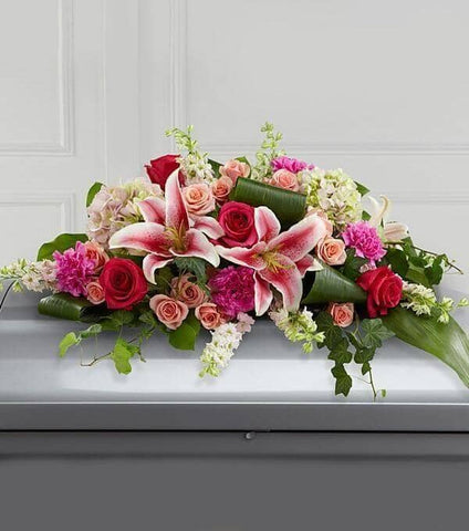 Splendid Grace™ Casket Spray - pink larkspur , hot pink roses , peach roses , fuchsia carnations , pink hydrangea , pink lilies , greens , aspidistra , salal , ivy vines , casket spray