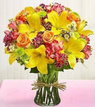 Sunny Blossom - yellow lilies , alstroemeria , orange roses , green button mums , pink waxflower , vase arrangement